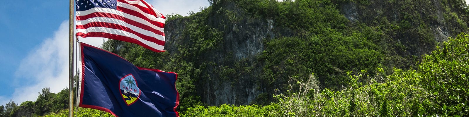 The Guam and U.S. flags pictured at Ritidian Point in the Guam National Wildlife Refuge.