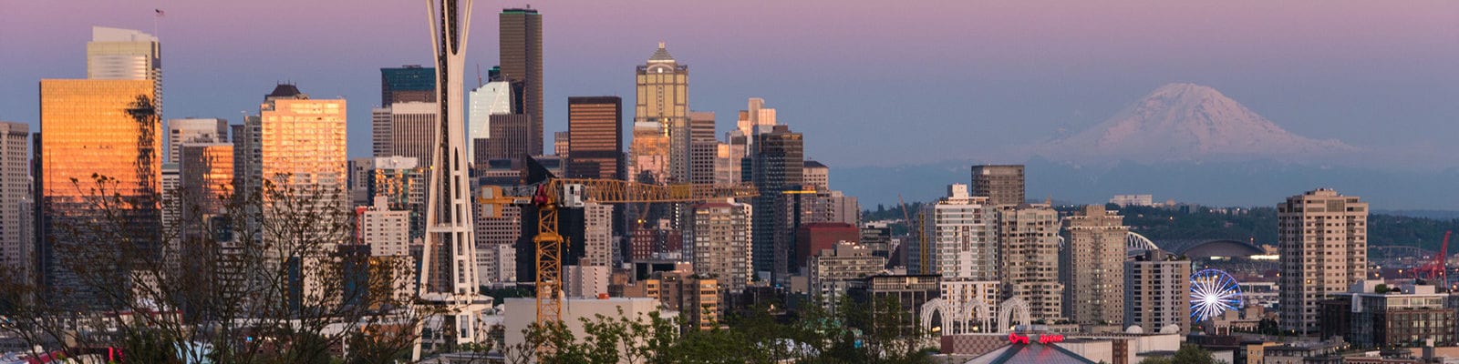 Photograph of a sunset view of Seattle, Washington with Mount Rainier in the background.